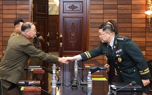 １３日午前、板門店の北朝鮮側統一閣で開かれた第４０回南北軍事実務会談に先立ち、韓国側首席代表である国防部のチョ・ヨングン北朝鮮政策課長（右）と北朝鮮側首席代表であるオム・チャンナム陸軍大佐が握手している。（写真＝国防部）