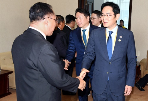 李在鎔（イ・ジェヨン）サムスン電子副会長（右）が１８日午後、平壌（ピョンヤン）人民文化宮殿で北朝鮮の経済を担当する李龍男（イ・ヨンナム）副首相（左）とあいさつしている。この日の面談に出席した財界人使節団は北朝鮮の関係者らと南北経済協力について話し合った。右から２人目から具光謨（ク・グァンモ）ＬＧ会長、・崔泰源（チェ・テウォン）ＳＫ会長（平壌写真共同取材団）