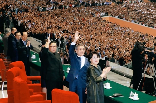 文在寅大統領と北朝鮮の金正恩国務委員長が１９日夜、平壌５・１競技場で開かれた『光る祖国』を観覧した後、歓呼する平壌市民に手をあげて挨拶している。（写真＝平壌写真共同取材団）