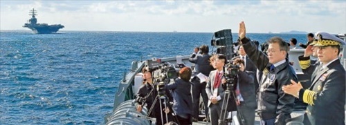 文在寅大統領が１１日、済州西帰浦近海上で開かれた国際観艦式で海上パレードに参加している。左側の遠く見える米原子力空母「ロナルド・レーガン」はこの日、海上パレードに参加した後、１２日済州海軍基地に入港する予定だ。（写真＝青瓦台写真記者団）