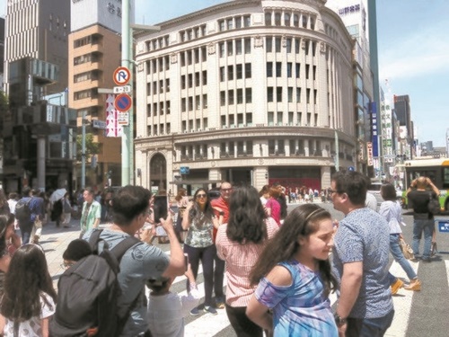 日曜日の６日、銀座中央通りの「歩行者天国」で写真を撮影している外国人観光客。