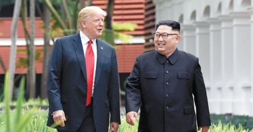 ６月１２日、シンガポールのカペラホテルで散策中の米国のトランプ大統領（左）と北朝鮮の金正恩国務委員長。（写真＝中央フォト）