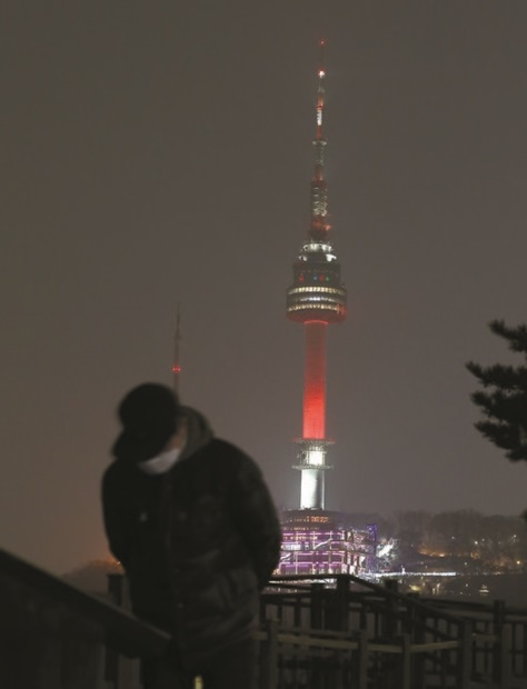 １４日午後、南山Ｎソウルタワーが赤色に点灯している。この日、ソウルの一日の平均ＰＭ２．５の濃度が歴代最高値である１２７マイクログラム／立方メートル（午後９時基準）を記録した。