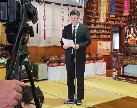 民和協の金弘傑代表常任議長が２７日、大阪統国寺で開かれた朝鮮人遺骨奉還式で追悼の挨拶を述べている。（写真提供＝民族和解協力汎国民協議会）