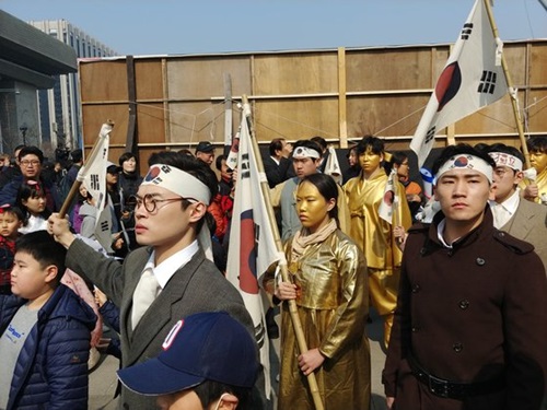 京畿道広州のパバル劇会の団員が光化門広場で独立活動家と日本軍の対立の様子を再演したパフォーマンスをする傍らで市民が記念撮影をしている。