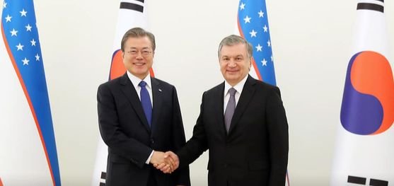 握手をする韓国の文在寅大統領とウズベキスタンのミルジヨエフ大統領。
