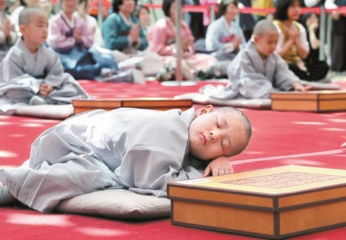 ２２日午前、ソウル鍾路区の曹渓寺で開かれた童子僧短期出家断髪受戒式で、ある童子僧が睡魔に勝てずまどろんでいる。