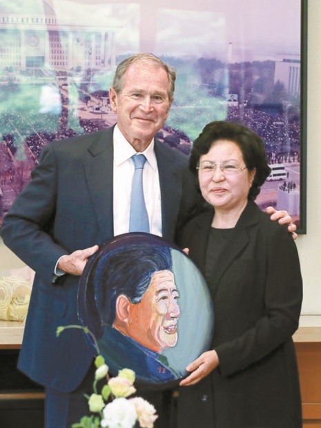 ２３日、ジョージ・Ｗ・ブッシュ元米国大統領（左）は追悼式に先立ち、私邸を訪問して自身が直接描いた盧元大統領の肖像画を権良淑夫人にプレゼントした。（写真＝盧武鉉財団提供）