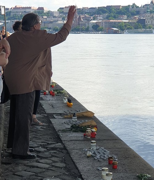 ２日（現地時間）、ハンガリー・ブダペストのドナウ川マルギット橋の下でハンガリー女性が花を投げて犠牲者を追慕している。