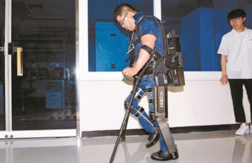 来年５月に開かれる「サイバスロン２０２０」に参加する予定の下半身麻痺障がい者のキム・ビョンウクさん（４５）が、ＫＡＩＳＴのコン・ギョンチョル教授チームが製作した着用型外骨格ロボット「ウォークオンスーツ」を着て歩く実演をしている。