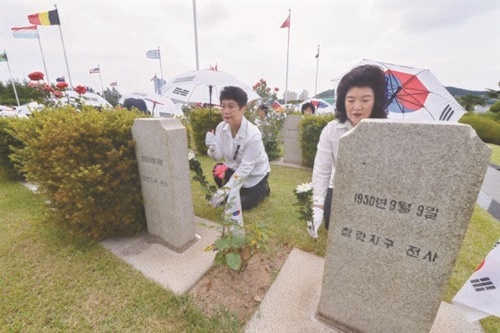 韓国戦争（朝鮮戦争）戦争勃発から６９年を迎えた２５日、釜山南区の国連記念公園で開かれた国連戦没勇士追悼祭で、韓国自由総連盟のメンバーが参戦勇士の墓に献花をしている