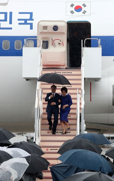 韓国の文在寅大統領が大阪で開かれるＧ２０サミット（２８～２９日）に参加するために２７日、日本を訪問した。雨が降る中、関西国際空港に到着した文大統領が金正淑夫人と傘を差して専用機から降りている。（写真＝青瓦台写真記者団）