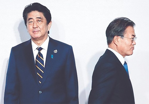 韓国の文在寅（ムン・ジェイン）大統領（右）が２８日、大阪で開かれた主要２０カ国・地域（Ｇ２０）首脳会議（サミット）歓迎式で、安倍晋三首相（左）と８秒間握手をした後、移動している。（写真＝青瓦台写真記者）