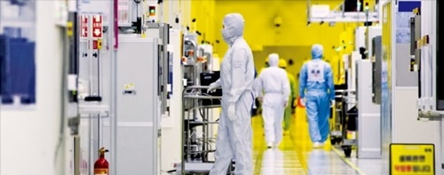 サムスン電子の職員が京畿道華城キャンパスの半導体生産ラインクリーンルームで半導体装備を点検している。（サムスン電子提供）