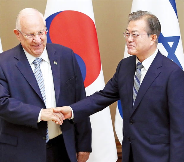 文在寅大統領（右）が１５日に青瓦台でイスラエルのリブリン大統領との首脳会談に先立ち握手している。イスラエル大統領の訪韓は２０１０年から９年ぶりだ。