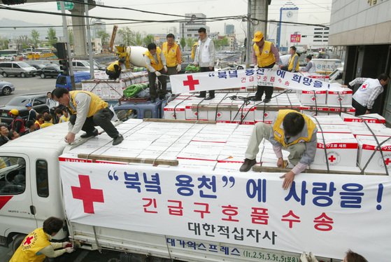 大韓赤十字社のボランティアメンバーが２００４年５月に大韓赤十字社ソウル支社で北朝鮮の竜川駅爆発事故現場に送る救護品をトラックに積んでいる。オ・ジョンテク記者