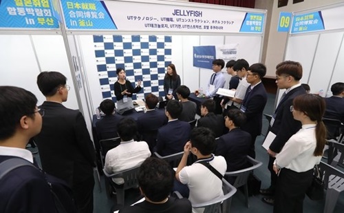 昨年８月、釜山市庁の大講堂で開かれた「２０１８日本就職合同博覧会ｉｎ釜山」で求職者が参加企業の説明を聞いている。当時、日本企業４３社が参加した。ソン・ボングン記者