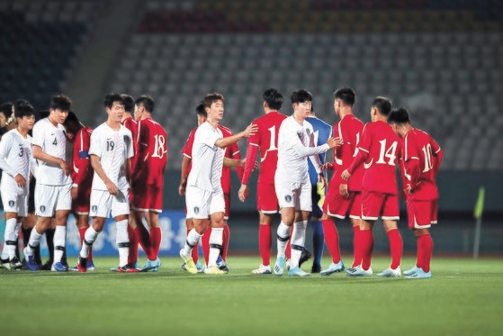 紆余曲折の末２９年ぶりに実現した男子サッカーの平壌（ピョンヤン）南北対戦が０－０の引き分けで終わった。５日、平壌金日成競技場で行われた試合の後、あいさつを交わす南北代表選手。［写真　大韓サッカー協会］
