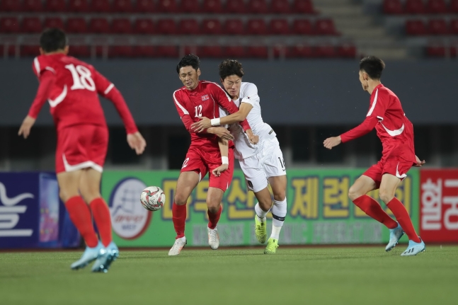 １５日、北朝鮮平壌の金日成競技場で行われた韓国－北朝鮮のＷ杯アジア地域２次予選Ｈ組第３戦で、黄儀助（ファン・ウイジョ）がイ・ヨンジク（１２番）が競り合っている。ベント監督が率いる韓国代表は接戦の末０－０で引き分けた。　［写真　大韓サッカー協会］