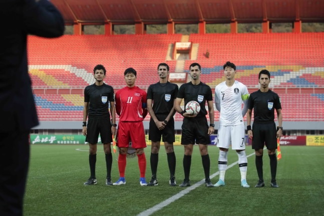 １５日、北朝鮮平壌の金日成競技場で行われたＷ杯アジア２次予選Ｈ組第３戦の韓国－北朝鮮戦で、孫興民と北朝鮮のチョン・イルグァンが記念撮影をしている。試合は接戦の末、０－０で終了した。［写真　大韓サッカー協会］