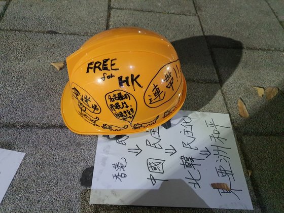 香港デモの象徴である「黄色いヘルメット」が集会場所に置かれている。ヘルメットの下にある紙には「香港の民主化が中国の民主化を促進し、これは北朝鮮の民主化を促進し、これを通じアジアの平和まで可能だ」という内容が書かれている。クォン・ユジン記者