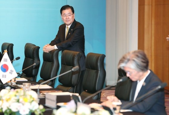 青瓦台の鄭義溶国家安保室長（左側）が２５日、釜山市内のホテルで開かれた韓国・タイ拡大首脳会談に参加し会議の始まりを待っている。右は外交部の康京和長官。カン・ジョンヒョン記者