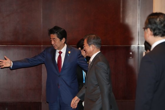 ２４日、文在寅大統領が韓日首脳会談のため会談場所に到着し、安倍首相が迎えている。　青瓦台写真記者団