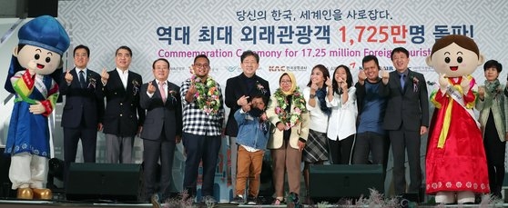 朴良雨・文化体育観光部長官をはじめ、韓国の観光当局者が２６日、１７２５万人目の入国外来客と一緒に記念写真を撮っている。［写真　韓国文化体育観光部］