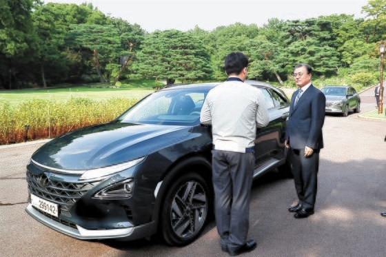 文在寅（ムン・ジェイン）大統領が青瓦台（チョンワデ、大統領府）で大統領専用車として導入した燃料電池車（ネクソ）について説明を聞いている。［青瓦台］