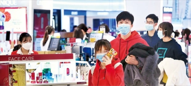 ソウル市が新型肺炎への対応警戒段階を発令した２８日、ソウル市内のある免税店で従業員と観光客がマスクを着用している。キム・ポムジュン記者
