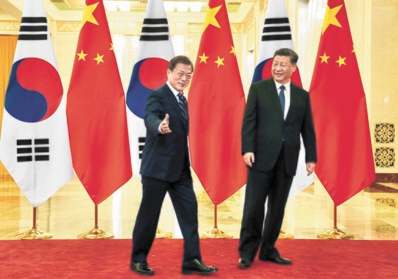 文在寅大統領（左）が昨年１２月２３日、中国北京人民大会党で習近平国家主席と韓中首脳会談の前に記念撮影をした後、会談場所に移動している。［青瓦台写真記者団］