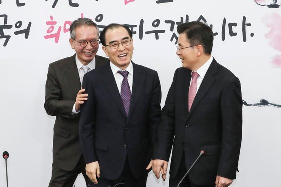太永浩元駐英北朝鮮公社（中央）が１１日、国会で自由韓国党入党と４・１５総選挙で地方区出馬を発表する記者会見を行い、黄教安代表と挨拶している。左はキム・ヒョンオ公認管理委員長。キム・ギョンロク記者