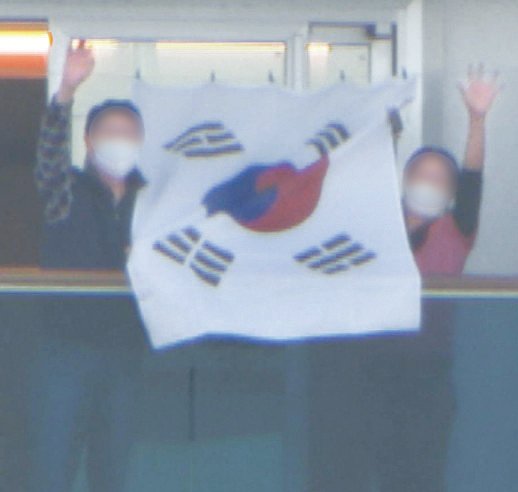 新型コロナ集団感染が発生したクルーズ船「ダイヤモンド・プリンセス」号に隔離された在日同胞６０代女性Ｋさん（右）が夫と共にベランダに掲げた太極旗を持ち上げている。ユン・ソルヨン特派員