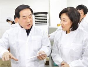 京畿道安養のマスク製造会社エバーグリーンのイ・スンファン代表（左）が朴映宣（パク・ヨンソン）中小ベンチャー企業部長官にマスク製造過程を説明している。