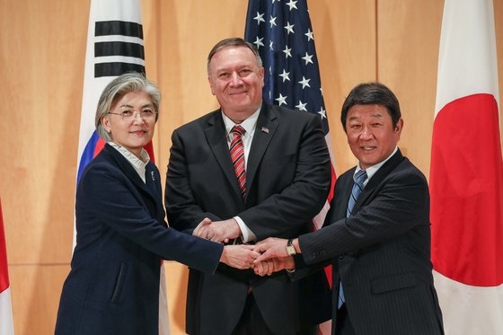 康京和（カン・ギョンファ）韓国外交長官、ポンペオ米国務長官、茂木敏充外相が今月１５日、独ミュンヘン安全保障会議で会談を終えた後、手を握り合っている。［写真　外交部］