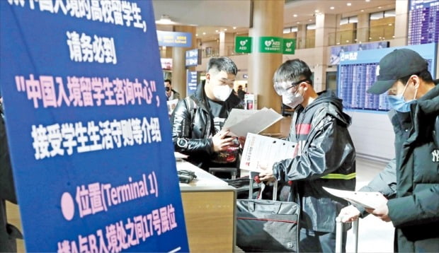 中国人留学生が２４日、仁川国際空港第１ターミナル到着ロビーに設けられた窓口で新型コロナウイルス感染症関連の案内を受けている。韓国教育部は中国人留学生１万人余りが入国予定の今週を「集中管理週間」と定め、特別管理システムを稼動することにした。キム・ヨンウ記者
