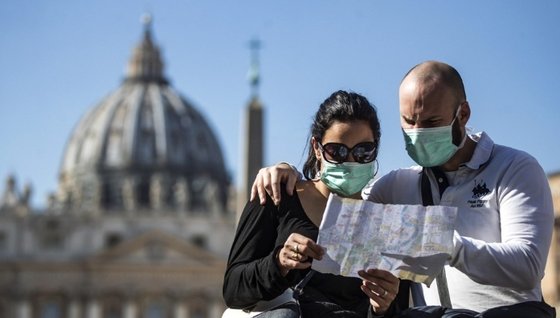 マスクをつけてバチカン・サンピエトロ広場前で地図を見るイタリア観光客