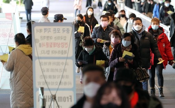 仁川（インチョン）国際空港で健康状態質問書を手にした中国発航空機の利用客が発熱検査のために移動している。チェ・チョンドン記者