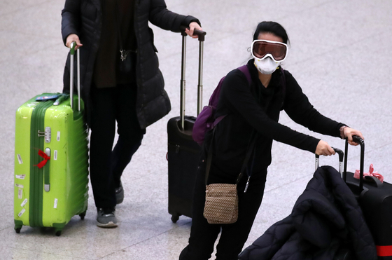 永宗島（ヨンジョンド）仁川（インチョン）国際空港でゴーグルと防塵マスクなどで重武装した外国人観光客が入国場を出ている。ビョン・ソング記者
