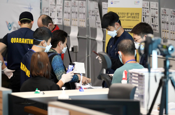 仁川国際空港第２ターミナルで乗客が検疫と連絡先確認など特別入国手続きを踏んでいる。