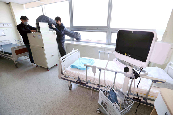新型コロナウイルス専門担当病院に指定された、ソウル中浪区（チュンナング）のソウル医療院病室で、陰圧器を設置する職員が機器を作動させながら確認している。陰圧器は病室内部の空気をフィルタリングしてウイルスのない状態にした後、外へ排出する装置だ。キム・サンソン記者