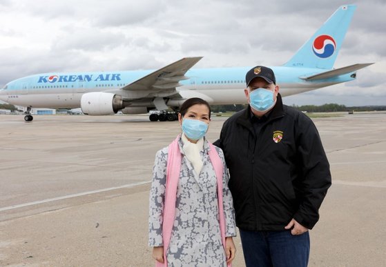 メリーランド州ラリー・ホーガン州知事（右）が妻のユミ・ホーガン夫人と空港で韓国の診断キットを迎えている。［ツイッター　キャプチャー］