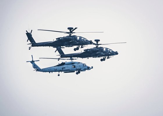 在韓米軍のＡＨ－６４アパッチ２機と米国海軍のＭＨ－６０Ｒシーホーク１機が太平洋で合同訓練をしている。［写真　米海軍］