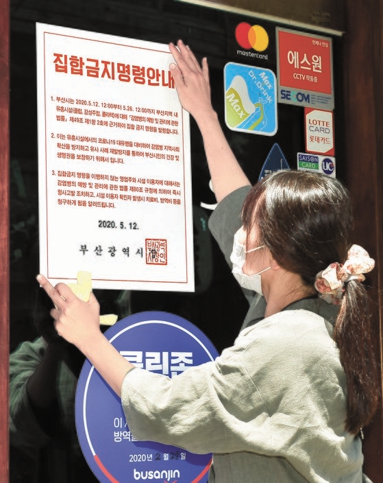 釜山市公務員が西面（ソミョン）一帯の遊興施設に集合禁止命令書を貼り付けている。釜山市は２６日までに計７１カ所の遊興施設に集合禁止命令を発令した。ソン・ボングン記者