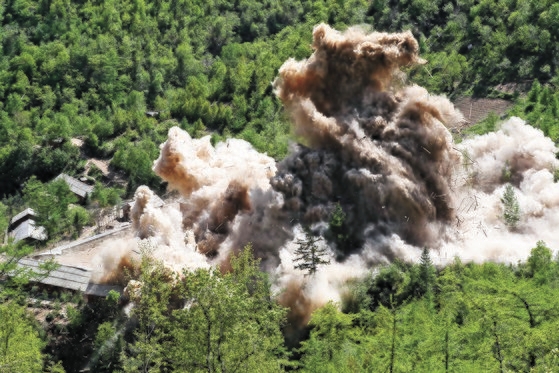２０１８年１１月２４日、北朝鮮核兵器研究所関係者が咸鏡北道吉州郡（ハムギョンブクド・キルジュグン）豊渓里（プンゲリ）核実験場閉鎖のための爆破作業を行った。豊渓里核実験管理指揮所施設爆破瞬間、木造建物が爆破されて粉々になっている。［写真　共同取材団］