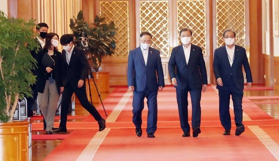 文在寅大統領が１日午後に青瓦台本館で開かれた第６次非常経済会議に参加している。右側は盧英敏秘書室長、左側は洪楠基経済副首相兼企画財政部長官。左側後方に新任の卓賢民儀典秘書官がついてきている。［写真　青瓦台写真記者団］