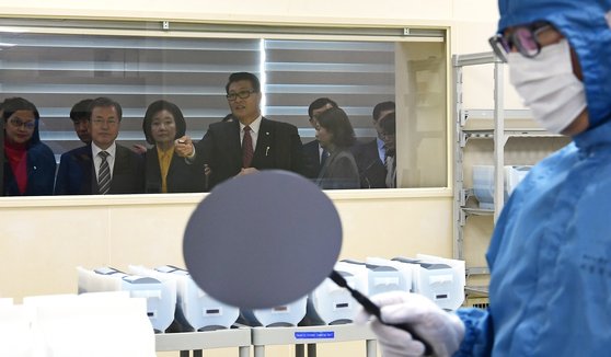 日本が半導体生産に使用される核心素材３品目の輸出規制を強化してから４カ月後の昨年１１月２２日、文在寅（ムン・ジェイン）大統領が天安（チョナン）のＭＥＭＣコリアの工場を訪問し、フッ化水素を使用するエッチング工程を見ている。［青瓦台写真記者団］