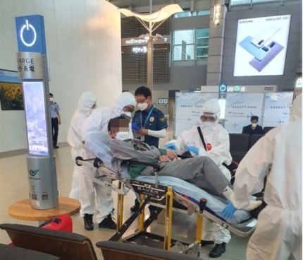 先月２５日、空港で野宿中に体調が悪化したベトナム系米国人が救助隊員に運ばれている。［仁川空港警察団提供］