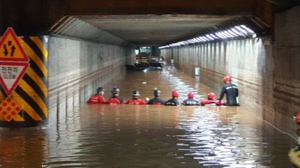 ２３日の豪雨で浸水した釜山市東区の草梁地下車道で救助隊員が救助作業をしている。［写真　釜山警察庁］