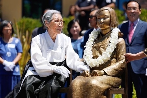 旧日本軍慰安婦被害者の故金福童（キム・ボクドン）さんが少女像に触れている。［中央フォト］